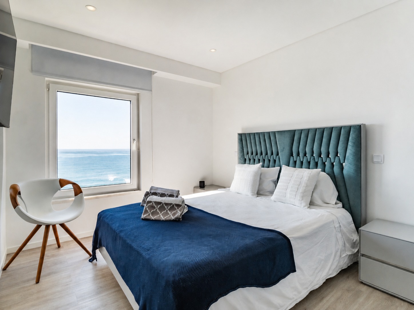 Quarto principal com cama de casal e janela sobre o oceano