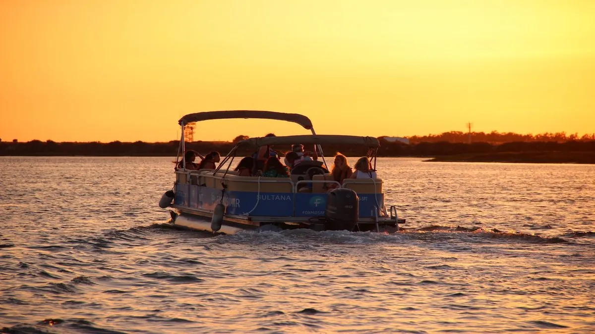 Formosamar boat carrying guests on calm water at sunset.