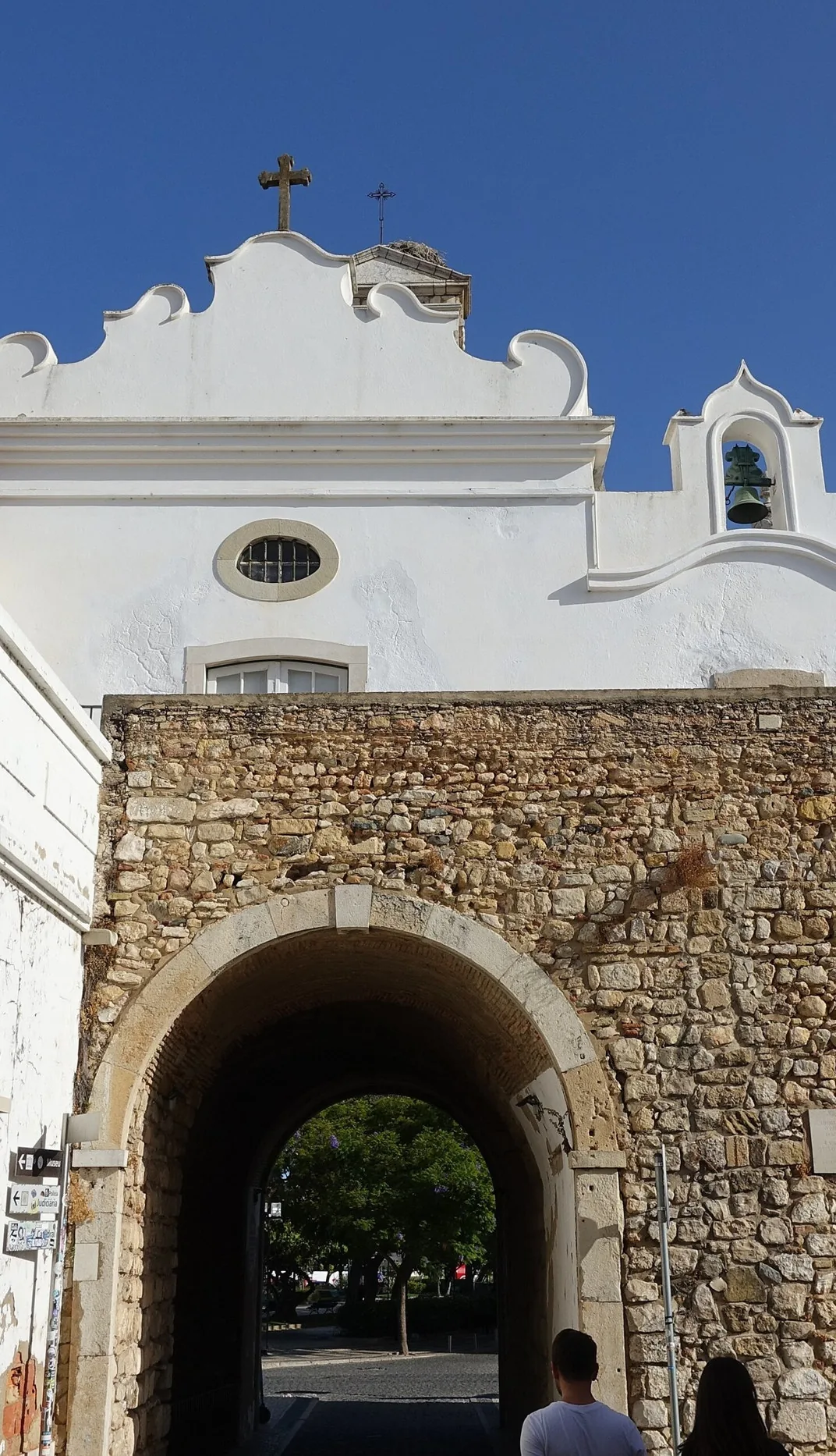 Faro’s Arco da Vila, with its stone arch, white façade and bell tower.