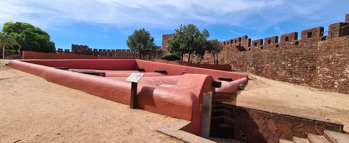 Red-stone ramparts and walkways inside Silves Castle.