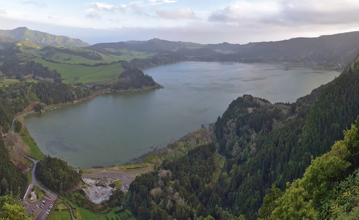 Lagoa das Furnas surrounded by wooded slopes, with Furnas village beyond.