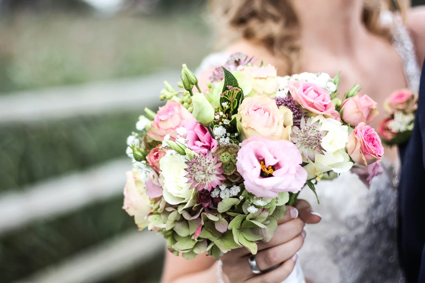 A close view of a bridal bouquet with pink, white and green flowers.